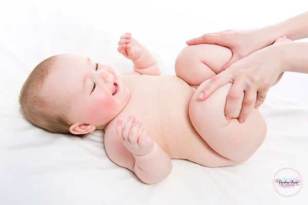 Mom is massaging baby's leg and releasing gas.